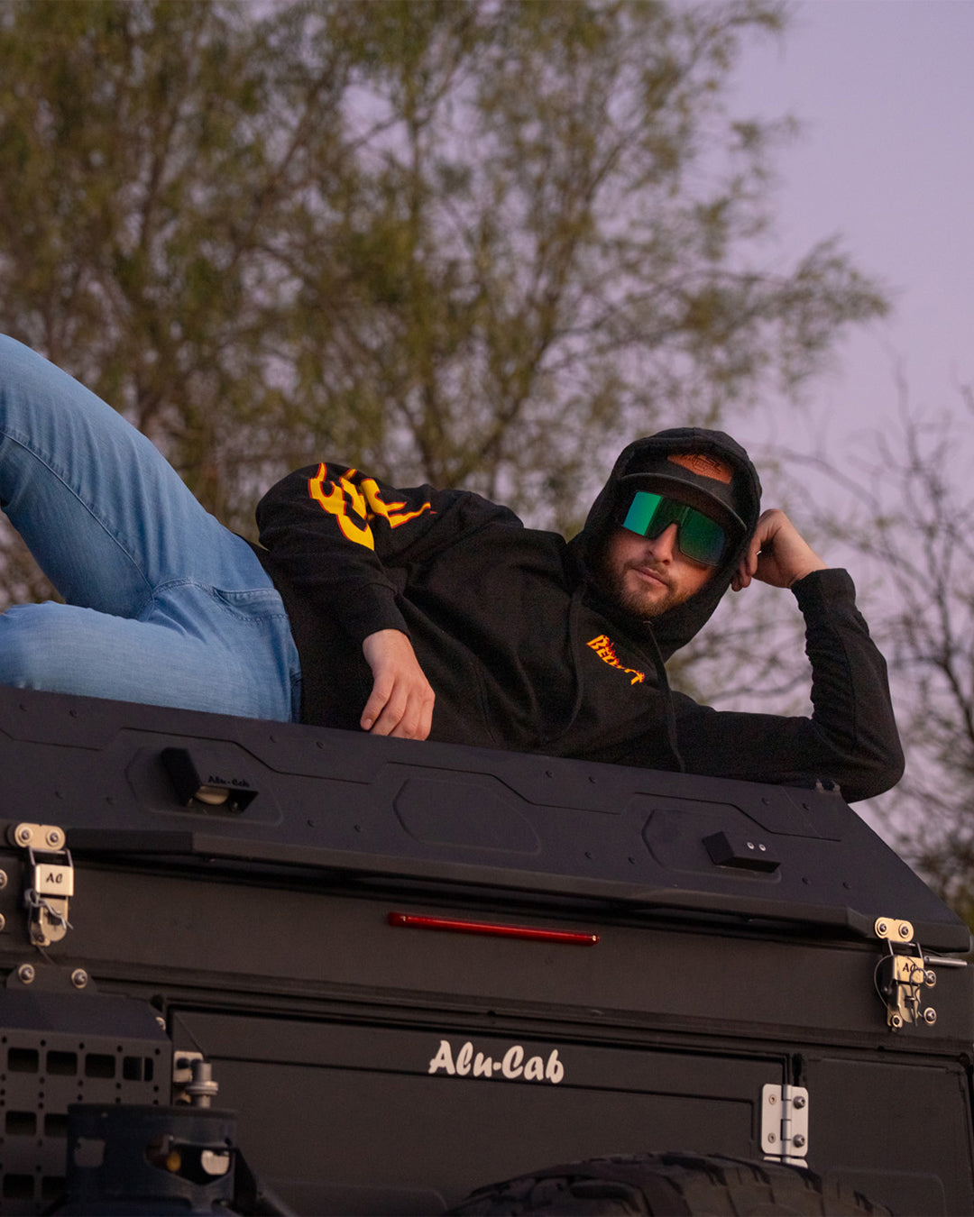 Man lounging on top of a truck in the Belt Hood