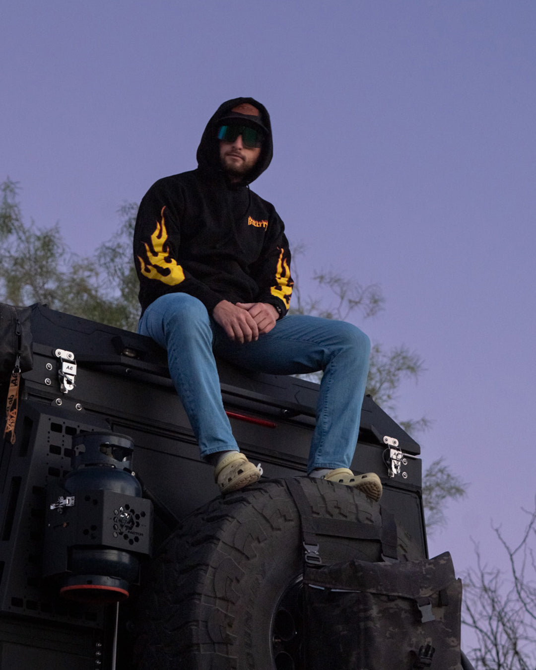 Man sitting on a truck at dusk in the Belt Hood
