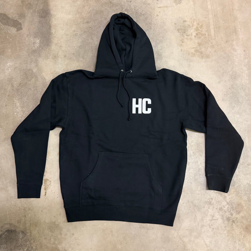 Black hoodie with 'HC' logo on a textured surface