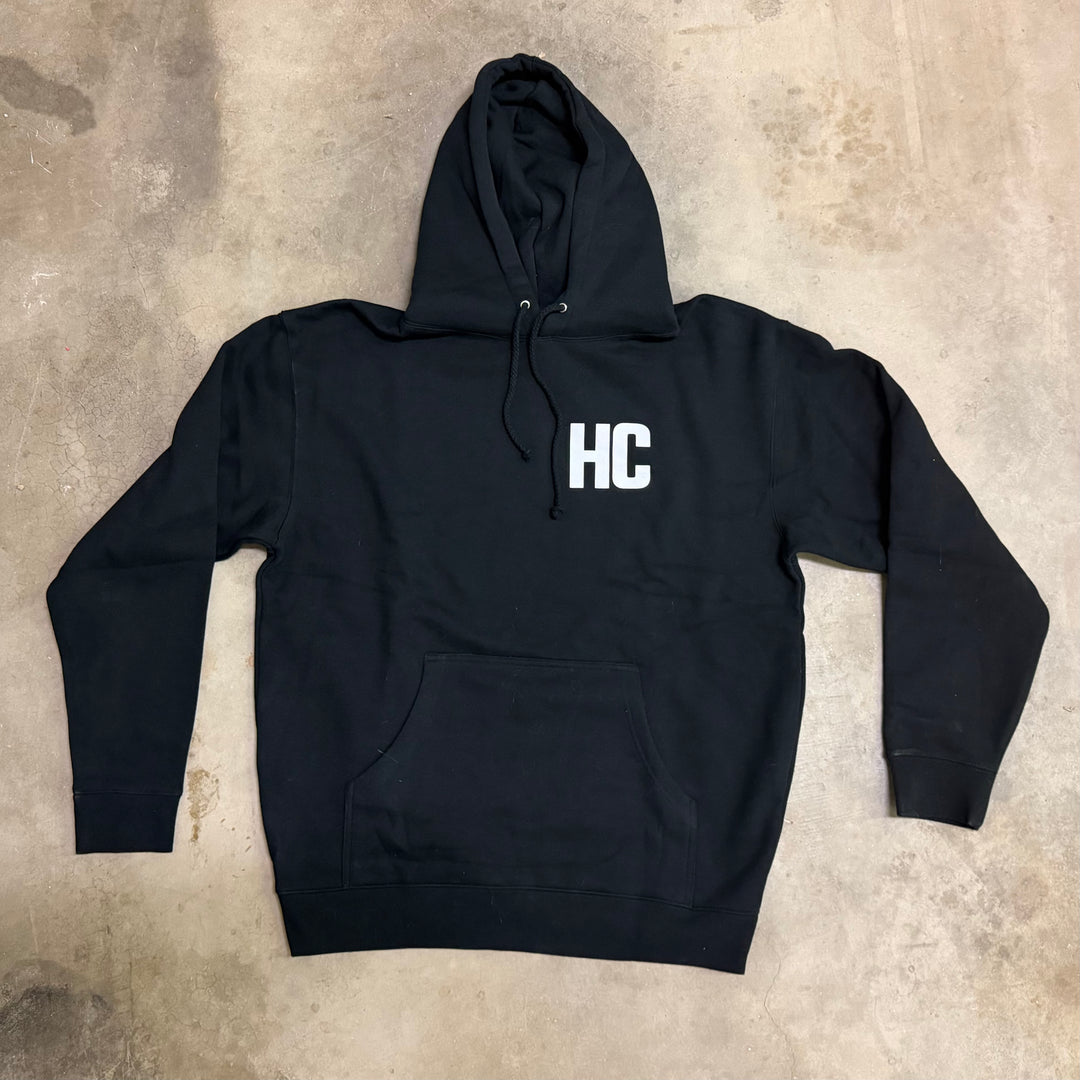 Black hoodie with 'HC' logo on a textured surface