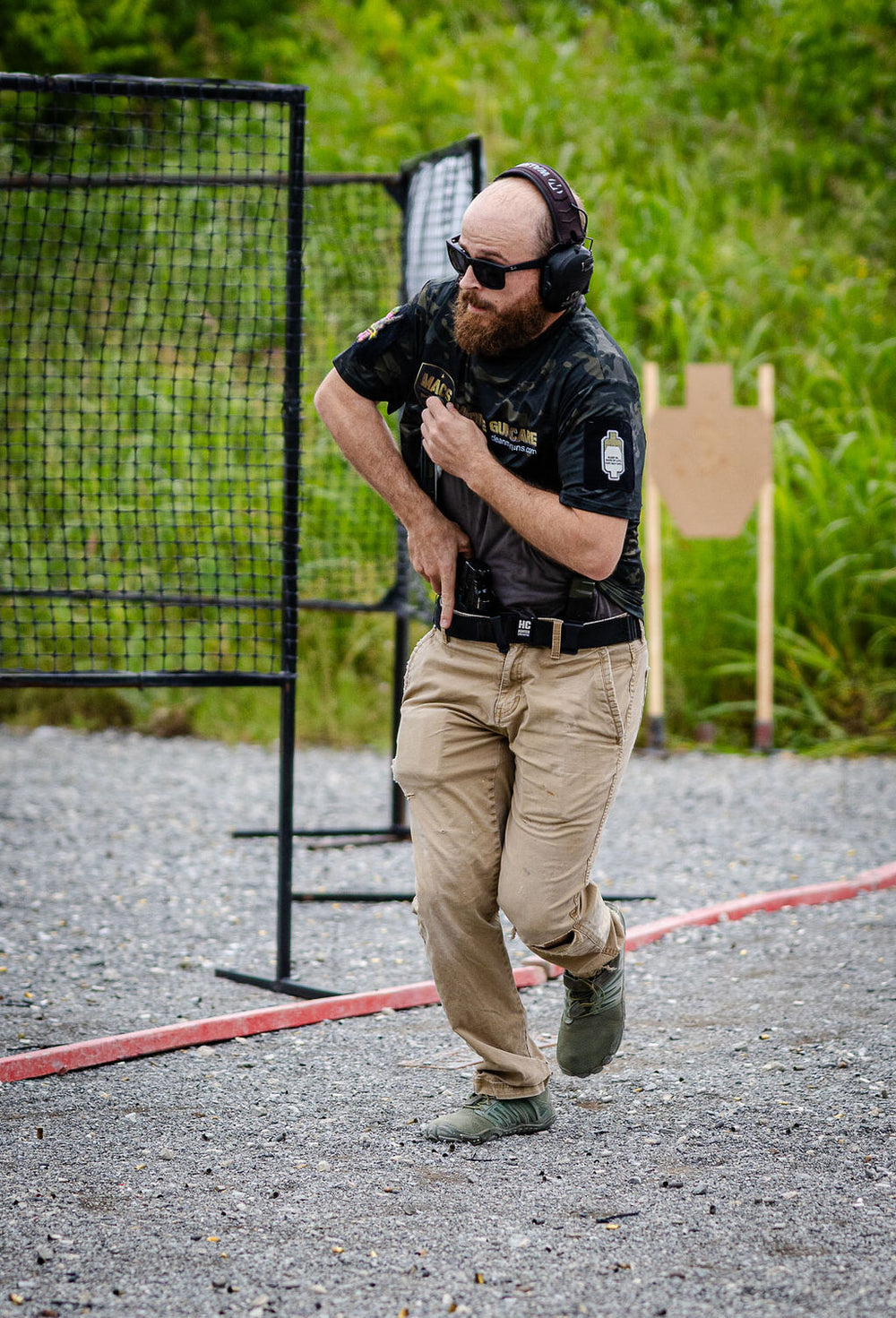 A competitor draws from under a concealment garment at the 2026 BELT championship