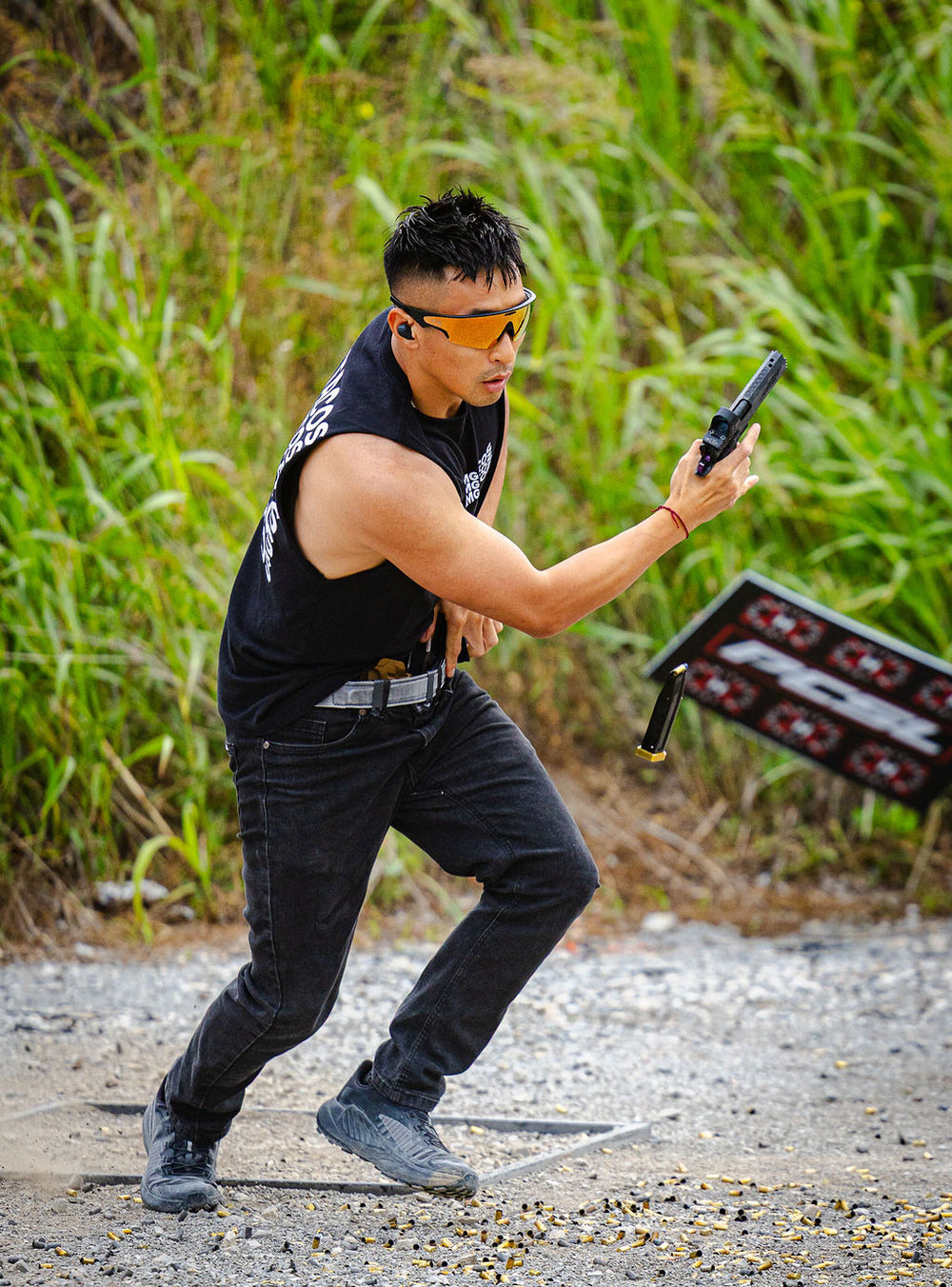 A competitor moves between positions, pistol in hand, at the 2026 BELT championship